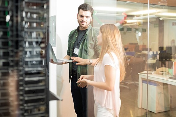 azure experience image of coworkers discussing servers in office with laptop